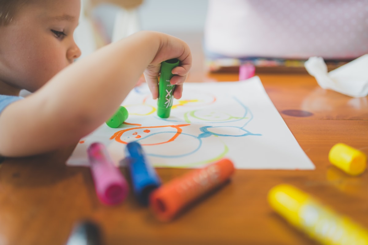 A child coloring a printable activity sheet at a craft table